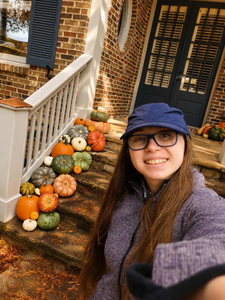 Pumkinful porch pumpkin artist in front a fall pumpkin display
