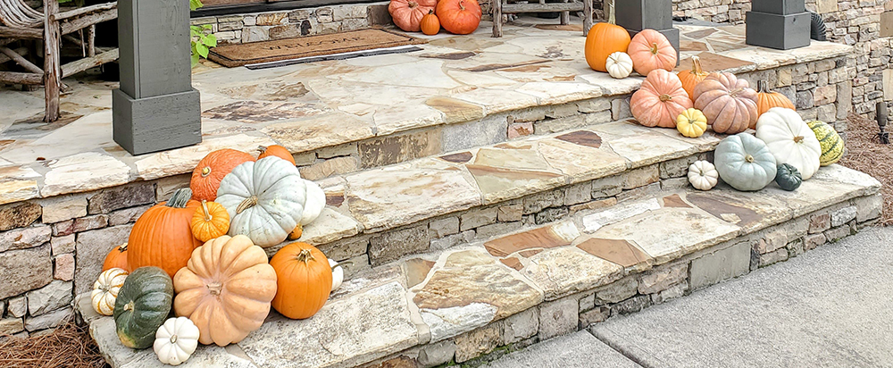 Custom fall porch design with pumpkin delivery and professional styling for an elegant autumn entrance.